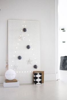 a white wall with some black and white objects on it's sides, next to a cardboard box