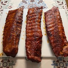 three pieces of meat sitting on top of a cutting board