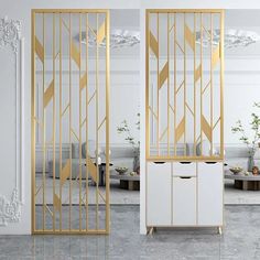 two doors with gold and white designs on them in an empty living room next to a couch