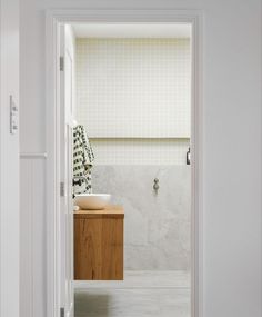 an open door leading to a white bathroom