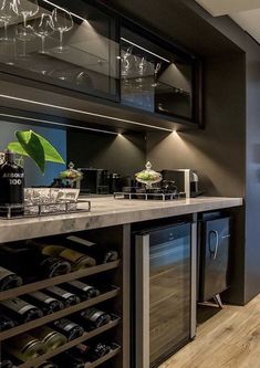 a kitchen with a wine cooler and lots of bottles