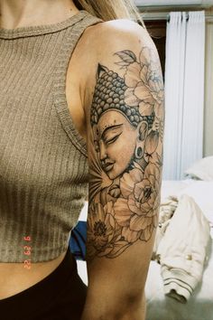 a woman with a buddha tattoo on her arm