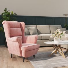 a living room with two pink chairs and a white coffee table in front of the couch