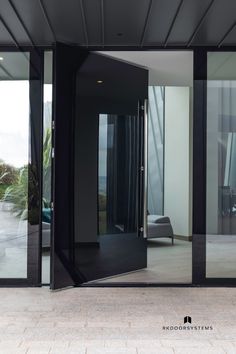 an open door leading into a living room with glass walls and doors on both sides