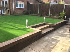 a backyard with artificial grass and wooden steps