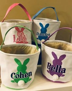 four buckets with different designs on them are sitting on a table and one has an easter bunny in the center