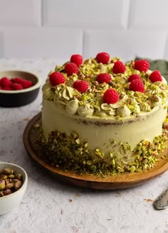 a cake with raspberries and pistachios on top