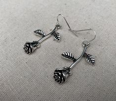 "These are simple stunning and unique! Single stem long rose earrings are exquisitely detailed and have incredible design. They would make the perfect gift for a loved one. A rose that never dies! The earrings measure 1 3/8\" long by 1/2\" wide at the flower part. Over all drop length is 1 1/2\". They hang from simple silver ear wire hooks. Made from allergy free plated silver. I have a matching necklace in my shop if you would like the whole set. Here is a direct link https://etsy.me/31ZuIRh Th Cheap Rose Design Dangle Earrings, Elegant Rose Dangle Earrings, Elegant Rose Sterling Silver Earrings, Rose Drop Earrings With Rose Design, Rose Color Flower Drop Earrings, Sterling Silver Rose Earrings With Rose Design, Rose Thorn Silver Earring, Silver Chandelier Earrings, Boho Hoop Earrings