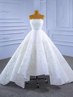 a white wedding dress on display in a room