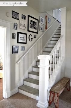 a staircase with pictures on the wall above it