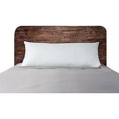 a bed with a wooden headboard and white pillows