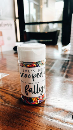 a glass jar filled with candy sitting on top of a wooden table