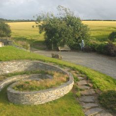 a stone bench sitting on top of a lush green field