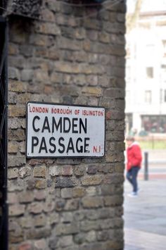 a sign on the side of a brick building that says camden passage no 1, london borough of sloughton