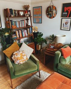 a living room filled with green couches and bookshelves next to each other