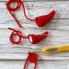 three crocheted hearts are shown next to a pair of yellow handled scissor