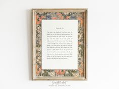 a framed poem with an orange and blue floral pattern on it's border is hung above a white wall