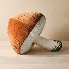 an orange and white mushroom sitting on top of a wooden table