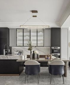 two chairs are sitting in front of a kitchen island with marble countertops and black cabinets