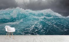 a chair sitting in front of an ocean wall mural