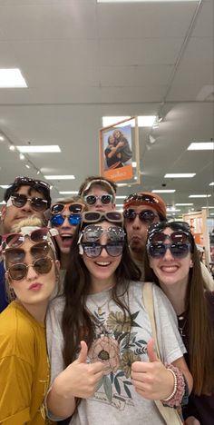 a group of people wearing sunglasses and giving the thumbs up sign in front of them