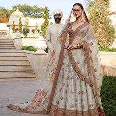 two people standing next to each other in wedding outfits