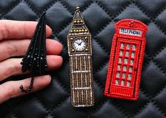 someone is holding two pins that look like they are from london and the big ben