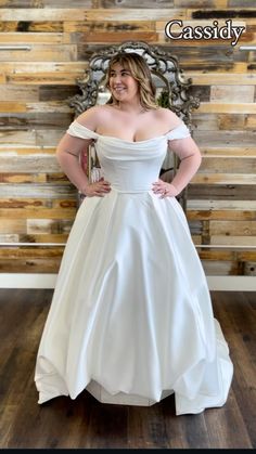 a woman in a white wedding dress posing for a photo with her hands on her hips