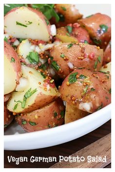 a white bowl filled with potatoes and herbs