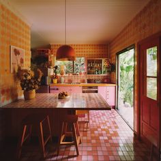 a kitchen with orange and pink tiles on the walls