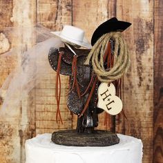 a cake topper with a cowboy hat and lasso on it's head