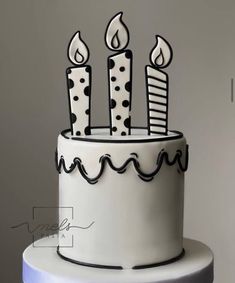 a white and black cake with polka dot candles