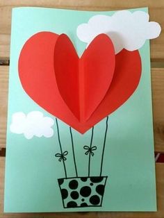 a card with two hearts floating in the air on top of a potted plant