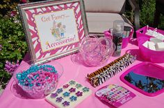 a pink table topped with lots of different items