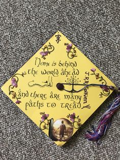 a yellow graduation cap with writing on it and a tassel hanging from the side