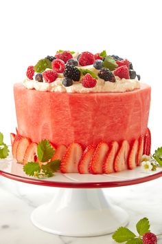 a watermelon cake with berries and whipped cream