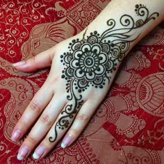 a woman's hand with henna tattoos on it