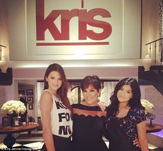 three women standing in front of a kris sign