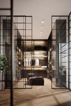 a walk - in closet with glass partitions and wooden flooring