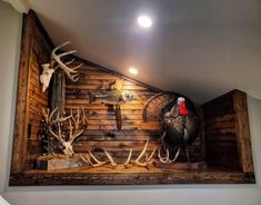 a wooden wall with antlers, deer heads and turkeys on it