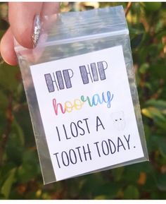 a person holding up a card with the words hip hip hooray i lost a tooth today