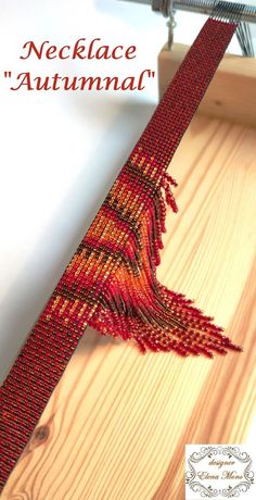 a piece of wood that has been beaded with red thread