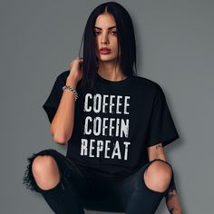 🖤 Just a friendly heads-up: to make sure your gifts arrive by Christmas, please place your orders by December 10th. Orders after that date might not reach you in time for the holiday. Thanks so much for your support, and happy holidays! I appreciate you guys! 🖤  Embrace the eternal ritual with this "Coffee, Coffin, Repeat" t-shirt--a stylish declaration of the undying cycle that fuels your nocturnal existence. Let the dark humor and grunge design be your daily mantra as you navigate through th Coffee Short Sleeve Shirt With Letter Print, Coffee Colored Short Sleeve Shirt With Letter Print, Coffee Crew Neck Top With Slogan, Coffee Colored Crew Neck Top With Slogan, Relaxed Fit Coffee Top With Funny Print, Coffee Short Sleeve Top With Text Print, Coffee Color Short Sleeve Top With Text Print, Coffee Colored Short Sleeve Slogan Top, Coffee Colored Slogan Short Sleeve Top