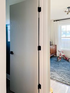 an open door leading to a bedroom with a bicycle parked in the room next to it