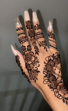 a woman's hand with henna tattoos on it