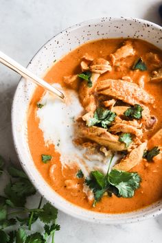 a white bowl filled with soup and garnished with cilantro