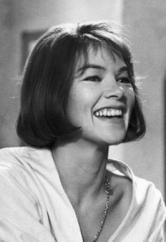 a black and white photo of a woman smiling