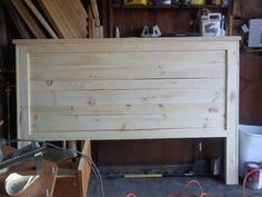 a bed frame made out of wood in a garage