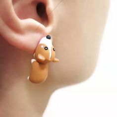 a close up of a person's ear with an animal shaped bead on it