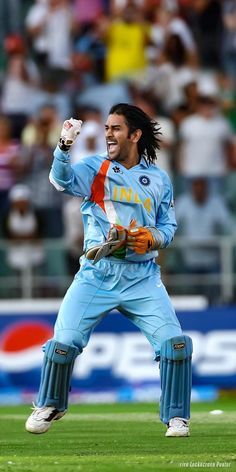 a man with dreadlocks on his head and arms in the air while standing on a field